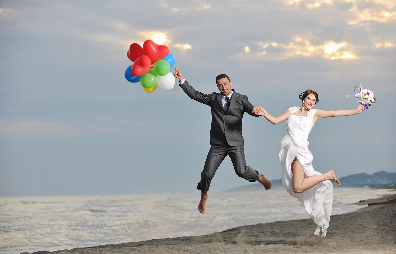 happy just married young couple celebrating and have fun at beautiful beach sunset